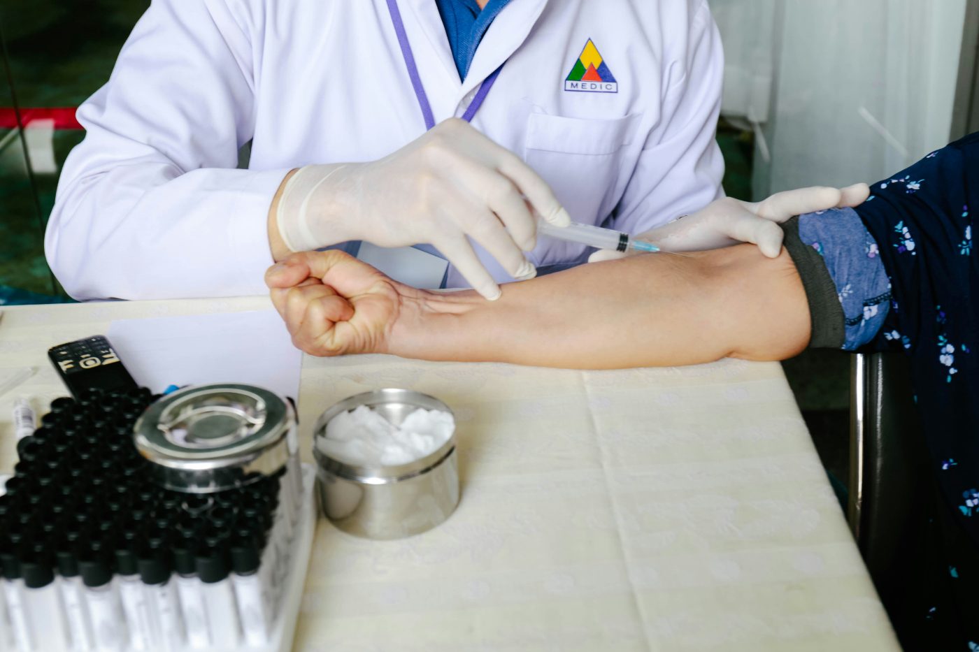 Technician drawing a blood sample from a patient during a full body checkup